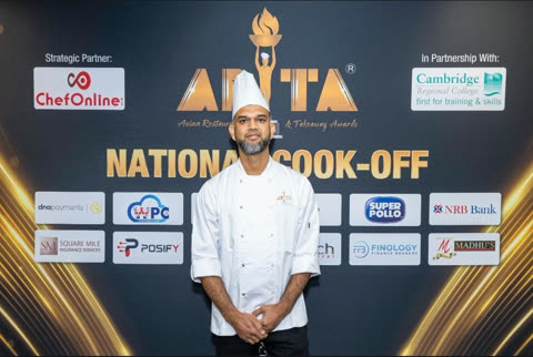 A Spice Merchants chef in whites in front of the ARTA National Cook-Off backdrop.